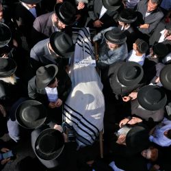 Hombres judíos ultraortodoxos participan en una ceremonia fúnebre en Jerusalén por una víctima de una estampida nocturna durante una reunión religiosa en el norte de Israel. | Foto:Menahem Kahana / AFP