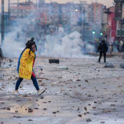 Colombia, Bogotá: una manifestante envuelta en la bandera colombiana camina durante los enfrentamientos con la policía antidisturbios en una protesta contra el proyecto de ley de reforma tributaria propuesto por el gobierno. | Foto:Chepa Beltran / LongVisual vía ZUMA Wire / DPA