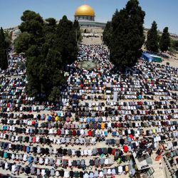 Una fotografía tomada con una lente de ojo de pez muestra a los fieles palestinos reunidos para orar fuera de la Cúpula de la Roca en el recinto de la Mezquita Al-Aqsa de Jerusalén, el tercer lugar más sagrado del Islam. | Foto:Ahmad Gharabli / AFP