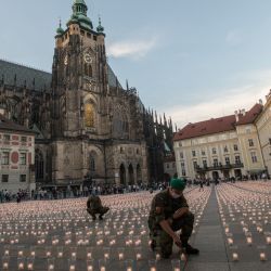 Un soldado enciende una vela para conmemorar a las víctimas de la pandemia COVD-19 en el Castillo de Praga en Praga. | Foto:Michal Cizek / AFP