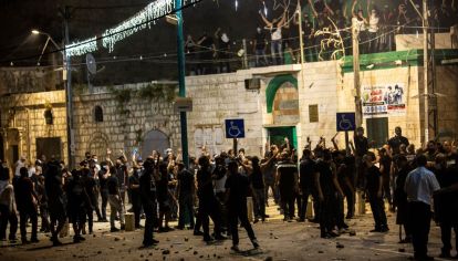 Un grupo de árabes se reúnen frente a una mezquita antes de chocar con manifestantes judíos en la ciudad de Lod.