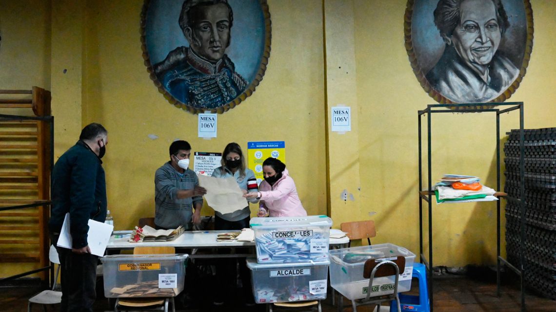 Members of the electoral table count votes at a polling station during elections to choose mayors, councillors and a commission to rewrite the constitution in Santiago, on March 16, 2021. 