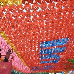 Un trabajador del templo coloca tarjetas con los deseos de los seguidores budistas en linternas de loto durante una ceremonia de celebración para conmemorar el cumpleaños de Buda en el templo Jogye en Seúl. | Foto:Jung Yeon-je / AFP