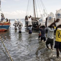 Hombres llevan sacos de arroz a un barco en Pemba. - Los sacos de arroz son llevados en piragua a Desplazados Internos en la isla de Ibo. Cientos de miles de personas han huido de la violencia desatada por los insurgentes islamistas en la provincia norteña de Mozambique durante más de tres años. | Foto:John Wessels / AFP