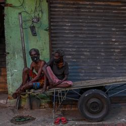 Los hombres se sientan en un carro de mano a lo largo de una calle durante las restricciones de viaje impuestas por el gobierno y el cierre de fin de semana para frenar la propagación del coronavirus Covid-19 en Colombo. | Foto:Ishara S. Kodikara / AFP