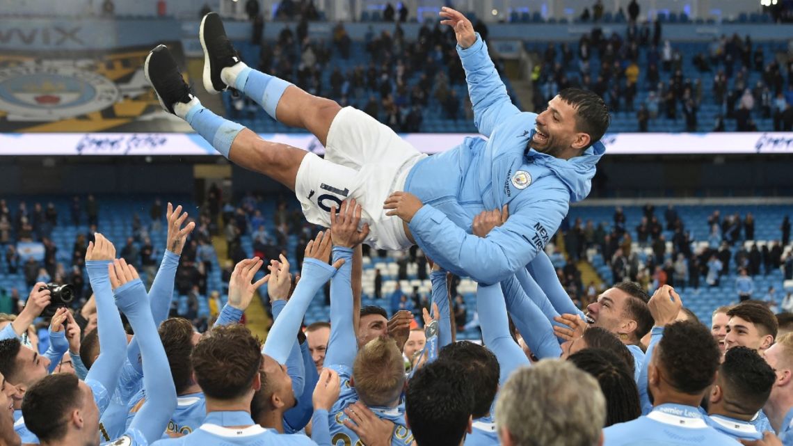 Players lifter Manchester City's Argentine striker Sergio Agüero aloft during the trophy award ceremony after the English Premier League football match between Manchester City and Everton at the Etihad Stadium in Manchester, on May 23, 2021. 