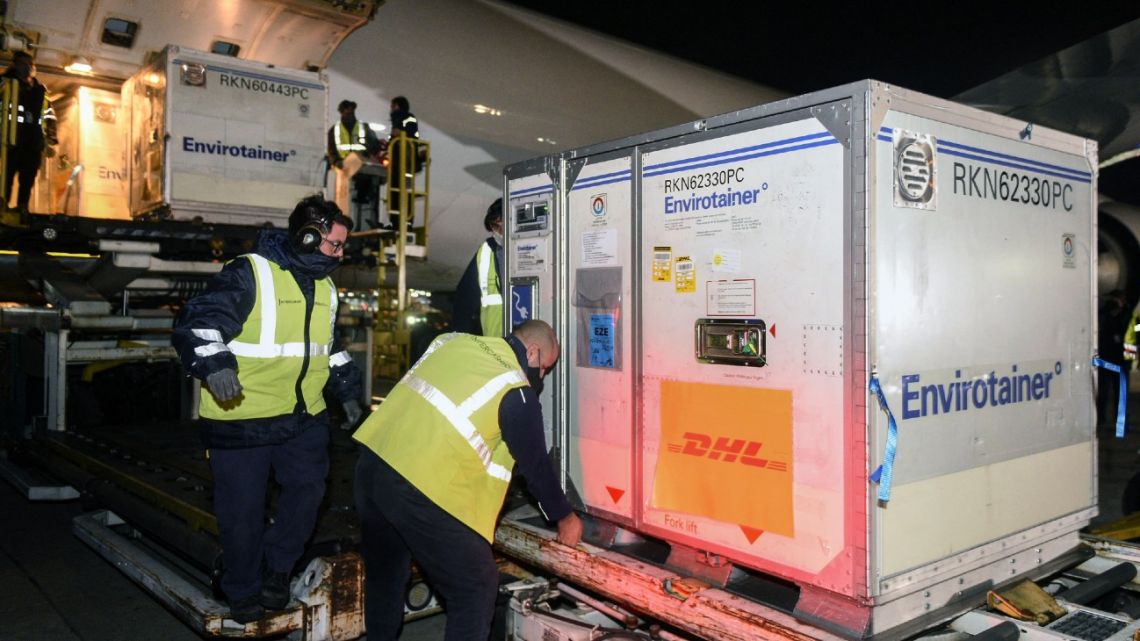 Handout photo released by the Presidency shows workers unloading containers with part of a shipment 843.600 AstraZeneca-Oxford Covid-19 vaccines upon their arrival at Ezeiza International airport in Buenos Aires Province, Argentina, on May 24, 2021. 