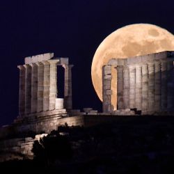 La flor de la luna llena se eleva detrás del Templo de Poseidón (Neptún) en el cabo Sunión, a unos 70 km al sur de Atenas. | Foto:Louisa Gouliamaki / AFP