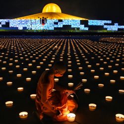 Un monje budista enciende velas para conmemorar el Día de Visakha Bucha o el Día de Vesak, una celebración del nacimiento, la iluminación y la muerte del Señor Buda que se lleva a cabo en la luna llena del tercer mes lunar del calendario budista, en el templo budista Wat Dhammakaya en las afueras. de Bangkok. | Foto:Lillian Suwanrumpha / AFP