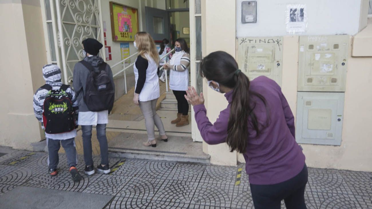 Alumnos de la escuela Escuela Nº9 D.E.9 “Juan Crisóstomo Lafinur” en el barrio porteño de Palermo ingresan esta mañana al retomar las clases presenciales.