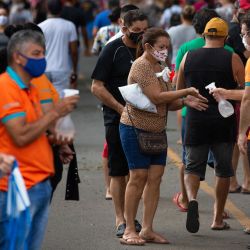 Los empleados ofrecen desinfectante a los visitantes en el cementerio de Nossa Senhora Aparecida, en Manaos, estado de Amazonas, Brasil, en medio de la pandemia del nuevo coronavirus COVID-19. | Foto:Michael Dantas / AFP