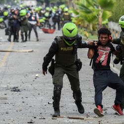 Policías colombianos arrestan a un manifestante durante una protesta contra el gobierno en Cali, Colombia. | Foto:Luis Robayo / AFP