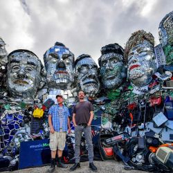 Los artistas Alex Wreckage y Joe Rush de Mutoid Waste Company posan para una foto frente a su obra de arte Mount Trashmore, en la playa de Gwithian. | Foto:Ben Birchall / PA Wire / DPA