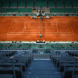 La ucraniana Marta Kostyuk devuelve la pelota a la polaca Iga Swiatek durante el partido de tenis femenino de la cuarta ronda nocturna en la Court Philippe-Chatrier el día 9 del torneo de tenis Roland Garros 2021 del Abierto de Francia en París. | Foto:Christophe Archambault / AFP