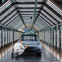 Un empleado revisa la superficie de un automóvil eléctrico Volkswagen ID 3 del fabricante de automóviles alemán Volkswagen, en el sitio de producción 'Glassy Manufactory' en Dresde, Alemania. | Foto:Jens Schlueter / AFP