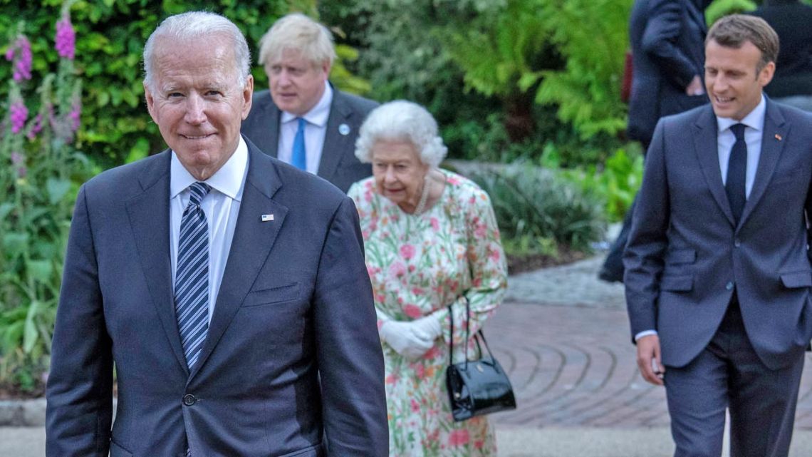 US President Joe Biden – with British Prime Minister Boris Johnson, Queen Elizabeth II and French President Emmanuel Macron in the background – attends the G7 Leaders Summit in Cornwall, England, on Friday, June 11, 2021.