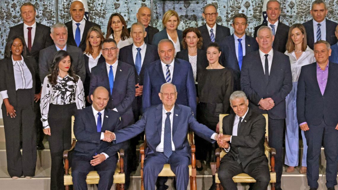 Outgoing Israeli President Reuvin Rivlin (centre) is flanked by Prime Minister Naftali Bennett (left) and alternate Prime Minister and Foreign Minister Yair Lapid during a photo with the new coalition government, at the President's residence in Jerusalem, on June 14, 2021. 