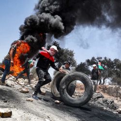 Manifestantes palestinos incendian neumáticos durante los enfrentamientos con las fuerzas de seguridad israelíes tras una manifestación en la aldea de Beita, al sur de Nablus, en la Cisjordania ocupada. | Foto:Jaafar Ashtiyeh / AFP