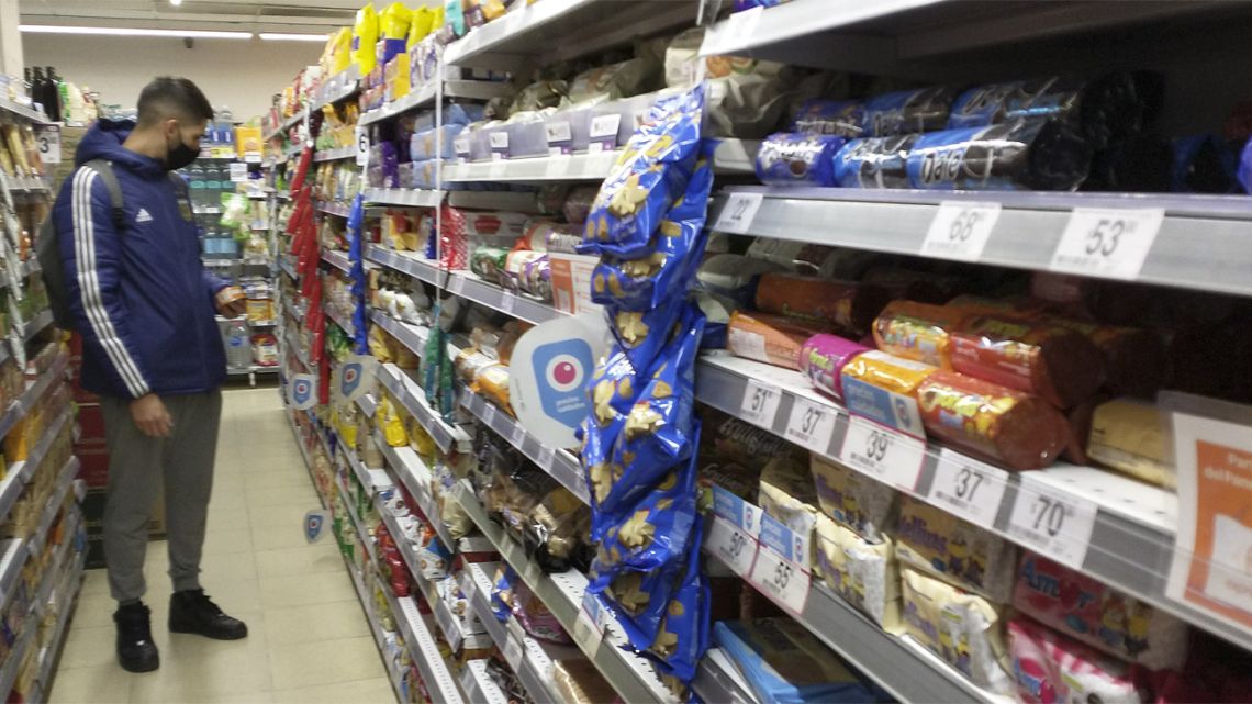 A shopper checks prices in a supermarket in Buenos Aires.