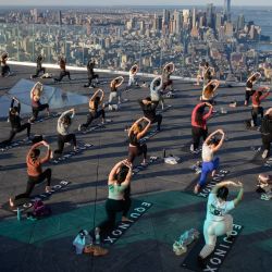 Practicantes de yoga asisten a una clase en el Edge Observation Deck, anunciado como la  | Foto:Ed Jones / AFP