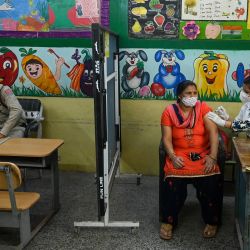 Un trabajador sanitario inocula a una mujer una dosis de la vacuna Covishield contra el coronavirus Covid-19 en una escuela utilizada temporalmente como centro de vacunación en Nueva Dehi. | Foto:Prakash Singh / AFP