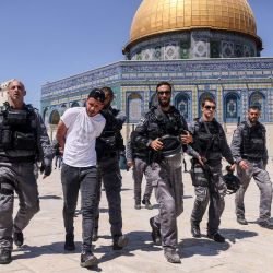 Miembros de la seguridad israelí llevan detenido un hombre palestino frente a la mezquita de la Cúpula de la Roca en Jerusalén, durante una protesta de los palestinos en respuesta a los cánticos de los ultranacionalistas israelíes dirigidos al profeta Mahoma en la Marcha de las Banderas. | Foto:Ahmad Gharabli / AFP