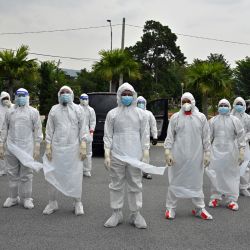 Voluntarios con trajes de protección posan para una foto antes de enterrar el cuerpo de una víctima del coronavirus Covid-19 en el cementerio musulmán Raudhatul Sakinah en Kuala Lumpur. | Foto:Mohd Rasfan / AFP