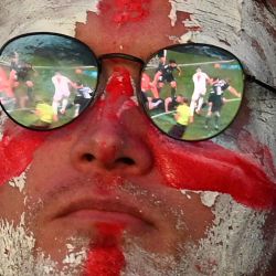 El partido de fútbol se refleja en los cristales de las gafas de un aficionado inglés mientras ve el partido de fútbol de la Eurocopa 2020 entre Inglaterra y Escocia que se juega en Londres. | Foto:Oli Scarff / AFP