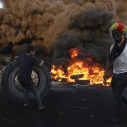 Palestinos queman neumáticos durante una manifestación nocturna contra la expansión de un asentamiento judío en las tierras de la aldea de Beita, cerca de la ciudad ocupada de Naplusa en Cisjordania. | Foto:Abbas Momani / AFP