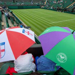 Los espectadores se refugian bajo sus paraguas en la pista número 2 de The All England Lawn Tennis and Croquet Club en el primer día del Campeonato de Tenis de Wimbledon 2021. | Foto:Edward Whitaker / Aeltc Pool/PA Wire / DPA