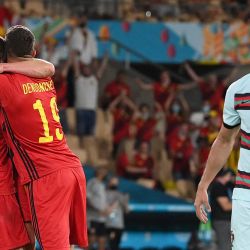 El delantero de Portugal Cristiano Ronaldo reacciona mientras los jugadores de Bélgica celebran su victoria al final del partido de fútbol de octavos de final de la Eurocopa 2020 entre Bélgica y Portugal en el estadio de La Cartuja en Sevilla. | Foto:Lluis Gene / POOL / AFP