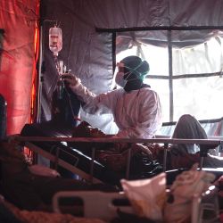 El personal médico atiende a los pacientes de Covid-19 en una tienda de campaña instalada fuera de un hospital en Bogor, mientras las infecciones se disparan en Indonesia. | Foto:Aditya Aji / AFP