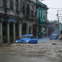 Coches y autobuses americanos antiguos circulan por una calle inundada en La Habana. - Las fuertes lluvias y el mal funcionamiento de las alcantarillas provocan la inundación de las calles de La Habana. | Foto:Yamil Lage / AFP