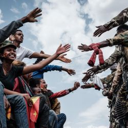 Los pasajeros de un autobús intentan tocar las manos de los soldados de la Fuerza de Defensa de Tigray (TDF) en un camión a su llegada a Mekele, la capital de la región de Tigray, Etiopía. | Foto:Yasuyoshi Chiba / AFP