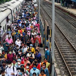Los pasajeros caminan por un andén después de llegar en un tren local de servicio especial tras las restricciones del transporte público como parte del bloqueo en curso para frenar la propagación del coronavirus Covid-19 en el estado de Bengala Occidental, en Calcuta. | Foto:Dibyangshu Sarkar / AFP