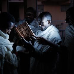 Sacerdotes ortodoxos etíopes y devotos, que huyeron de la violencia en la región etíope de Tigray, celebran una oración antes del amanecer en un pasillo de la escuela secundaria May Weyni, que se convirtió en un campo de desplazados internos que registra a 1.500 personas, en Mekele, la capital de la región de Tigray, Etiopía. | Foto:Yasuyoshi Chiba / AFP