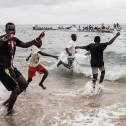Los seguidores reaccionan cuando su equipo gana durante una carrera de piraguas tradicional senegalesa en Dakar. | Foto:John Wessels / AFP