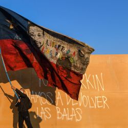 Un manifestante agita una bandera nacional chilena durante una marcha hacia el antiguo Congreso Nacional de Chile donde se inaugurará la Asamblea Constituyente en Santiago. | Foto:Martin Bernetti / AFP