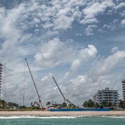 Unas grúas marcan el horizonte en el lugar donde tuvo lugar una demolición controlada del condominio Champlain Towers South, de 12 pisos, parcialmente derrumbado en Surfside, Florida. | Foto:Giorgio Viera / AFP