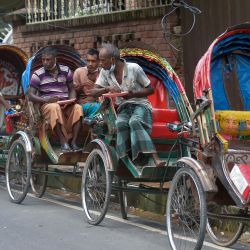 Tiradores de rickshaw comen alimentos distribuidos por la organización sin ánimo de lucro Mehmankhana durante el bloqueo nacional impuesto para frenar la propagación del coronavirus Covid-19 en la zona de Lalmatia de Dhaka. | Foto:Munir Uz zaman / AFP