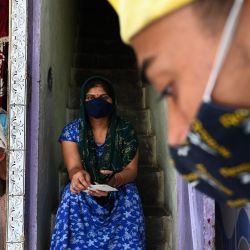 Un voluntario de la fundación Turn Your Concern into Action (TYCIA) habla con los residentes durante una campaña puerta a puerta para registrar a las personas para la vacunación contra el coronavirus Covid-19 en Nueva Delhi. | Foto:Sajjad Hussain / AFP