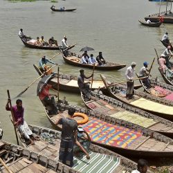Los transeúntes se abren paso a través de los botes en el río Buriganga durante un estricto cierre nacional de una semana de duración patrullado por la policía y las tropas como medida preventiva contra el coronavirus Covid-19 en Dhaka. | Foto:Munir Uz Zaman / AFP