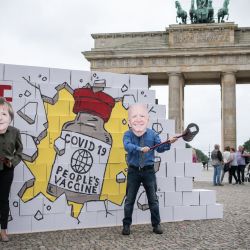 Activistas de Avaaz con máscaras en las que aparecen la canciller alemana Angela Merkel y el presidente estadounidense Joe Biden organizan una protesta bajo el lema  | Foto:Stefanie Loos / AFP