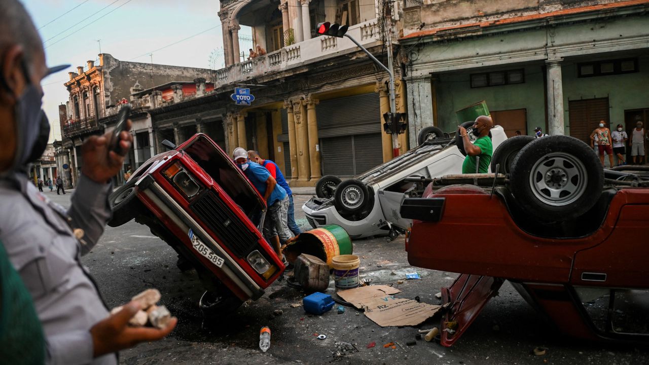 En la foto se ven coches de la policía volcados en la calle en el marco de una manifestación contra el presidente cubano Miguel Díaz-Canel en La Habana. | Foto:Yamil Lage / AFP
