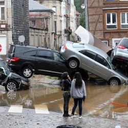 La imagen muestra a la gente pasando junto a los coches amontonados en una rotonda en la ciudad belga de Verviers, después de que las fuertes lluvias e inundaciones azotaran el oeste de Europa, matando al menos a dos personas en Bélgica. | Foto:François Walschaerts / AFP