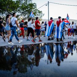 Personas sostienen banderas cubanas y estadounidenses mientras marchan durante una protesta que muestra el apoyo a los cubanos que se manifiestan contra su gobierno, en Hialeah, Florida. | Foto:Eva Marie Uzcategui / AFP