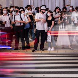 Los peatones esperan para cruzar una carretera en el distrito de Shinjuku, en Tokio. | Foto:Philip Fong / AFP