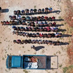 Una vista aérea muestra a los dolientes rezando sobre los cuerpos de tres niños, que murieron en un bombardeo de artillería del régimen en las afueras de la ciudad de Fuaa, durante una procesión fúnebre en un cementerio en Binnish en la provincia noroccidental de Idlib, controlada por los rebeldes. | Foto:Omar Haj Kadour / AFP