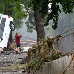 Un hombre junto a un coche destruido toma una foto de la zona devastada tras las inundaciones que causaron grandes daños en Bad Neuenahr-Ahrweiler, al oeste de Alemania. | Foto:Christof Stache / AFP