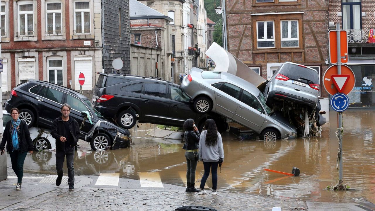 La imagen muestra a la gente pasando junto a los coches amontonados en una rotonda en la ciudad belga de Verviers, después de que las fuertes lluvias e inundaciones azotaran el oeste de Europa, matando al menos a dos personas en Bélgica. | Foto:François Walschaerts / AFP